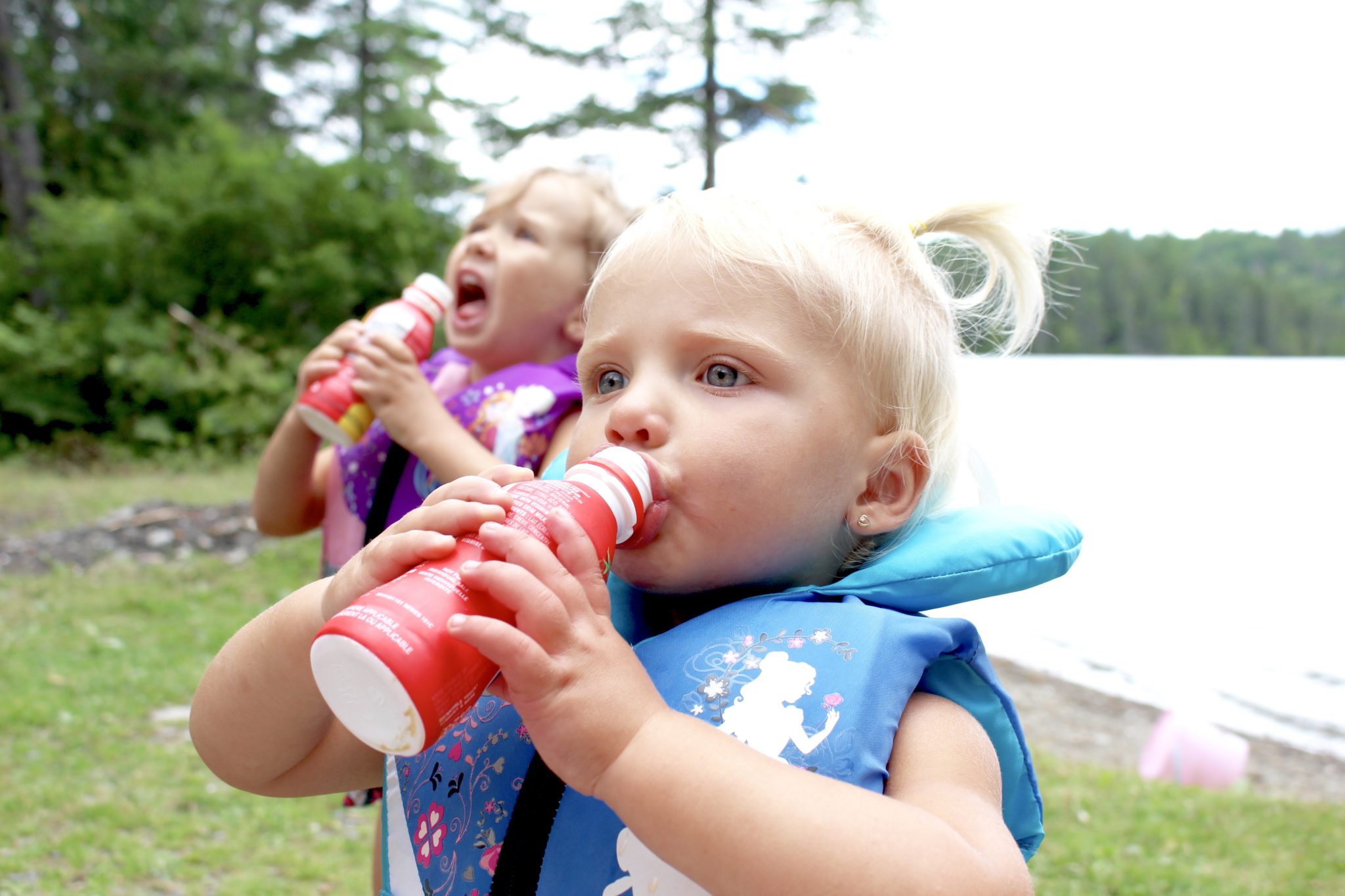 Toddler girl drinking water from the baby bottle Stock Photo