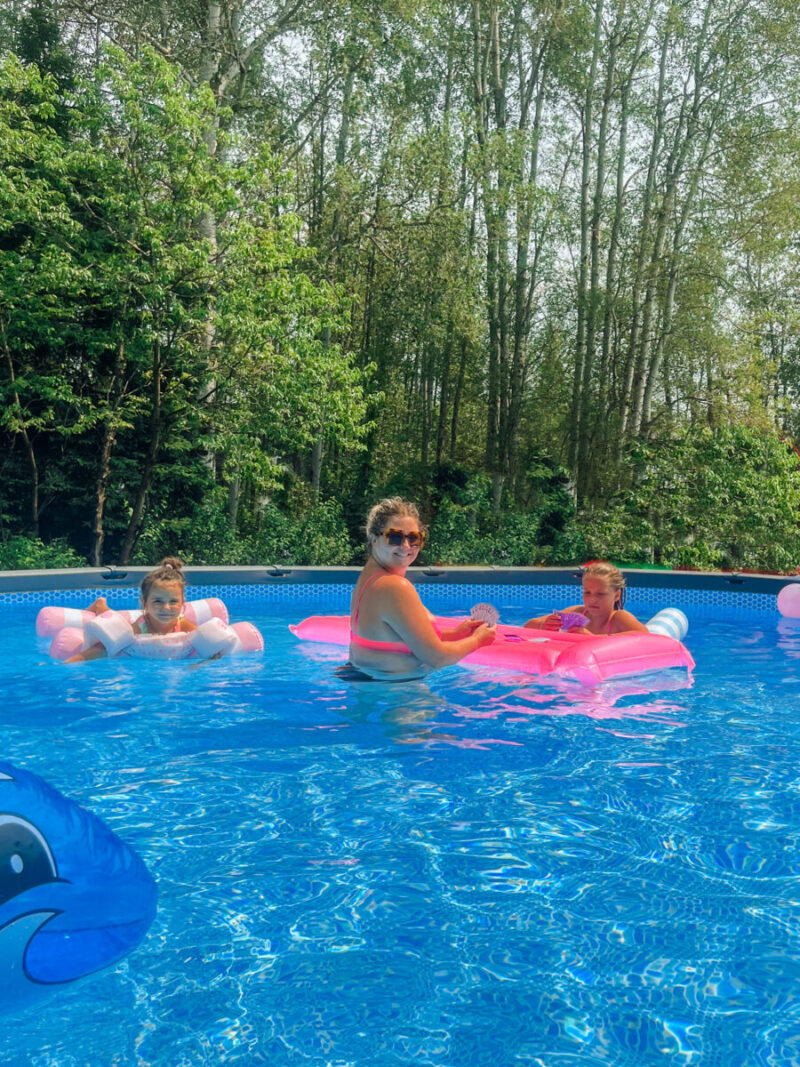 Family fun mother and daughters playing with waterproof playing cards and pool floats in our Intex Ultra XTR above ground pool